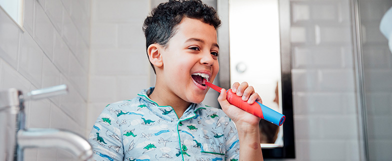 Child brushing teeth in the morning.