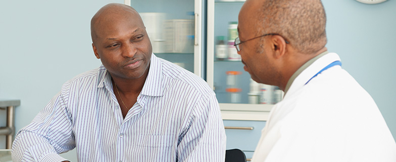 Man talking to doctor about screenings.