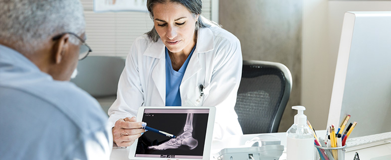 Doctor showing patient xray of fracture on an ipad.