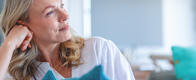 Woman thinking, sitting on couch.