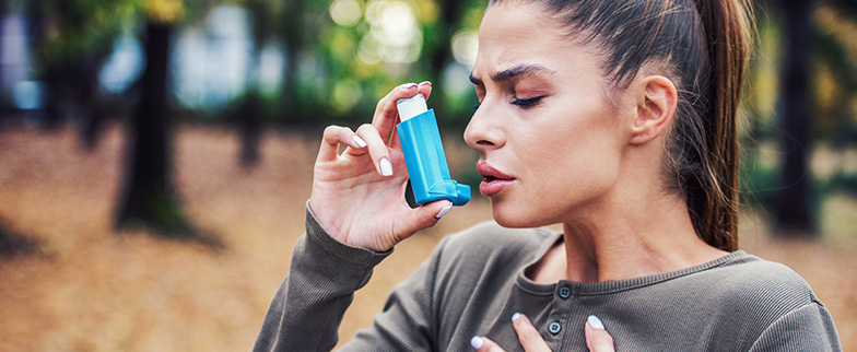 Woman using inhaler.