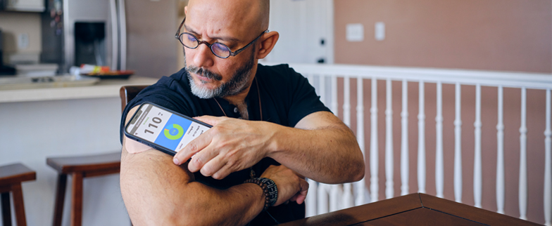 Adult using their phone to check their blood pressure in their home.