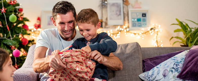 Family opening Christmas presents on Christmas morning in their home. 